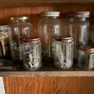 Sale Photo Thumbnail #57: Assorted vintage glass jars filled with nails, screws, and hardware.