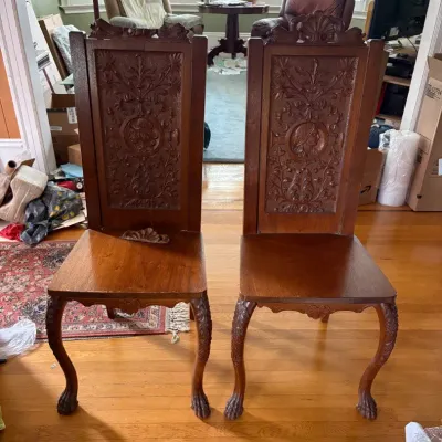 Sale Photo Thumbnail #26: Pair of antique carved hall chairs featuring high backs with ornate relief carvings.