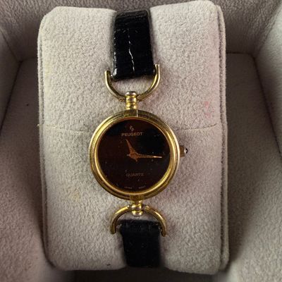 Sale Photo Thumbnail #46: A Ladies Peugeot Gold Toned Quartz Wristwatch with Case