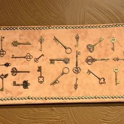 Decorative Multi-Row Collection of Approximately 50 Cast Metal Fantasy Keys on Upholstered Wall Display