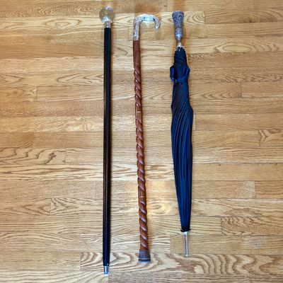 A Trio of Items Including Two Walking Canes and One Long Handle Umbrella