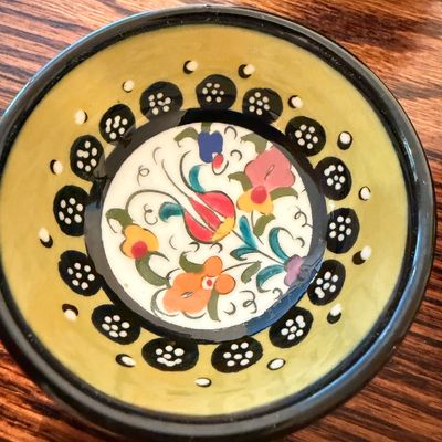 Sale Photo Thumbnail #100: Hand-painted ceramic trinket bowl featuring colorful floral motifs inside a yellow and black rim.