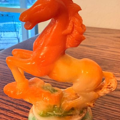 Sale Photo Thumbnail #85: Vintage carved orange and cream alabaster or soapstone rearing horse figurine mounted on a round base.