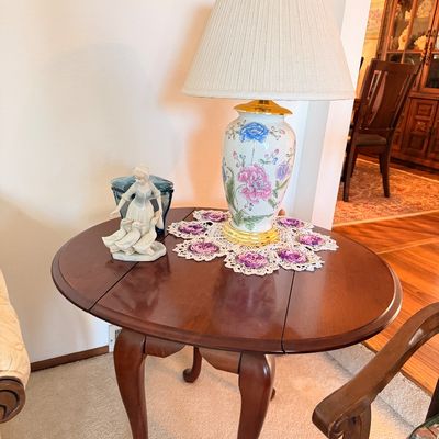 Sale Photo Thumbnail #6: Vintage mahogany drop-leaf accent table with cabriole legs, displaying a floral ceramic table lamp and a porcelain figurine.