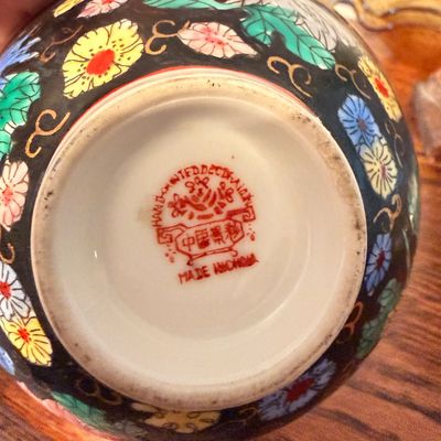 Sale Photo Thumbnail #97: Underside of a Chinese hand-painted porcelain vessel, showing a red stamped maker's mark and 'MADE IN CHINA' label.