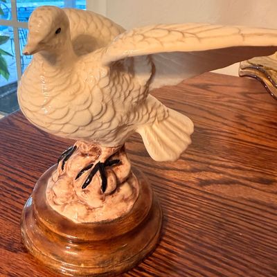 Sale Photo Thumbnail #88: Vintage glazed ceramic bird figurine featuring a white bird with outstretched wings resting on a brown-glazed pedestal base.
