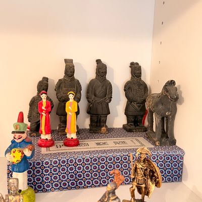 Sale Photo Thumbnail #42: Collection of miniature figurines, including replica Terracotta Army warriors, traditional Asian figures in red and yellow attire, and small metal soldiers.