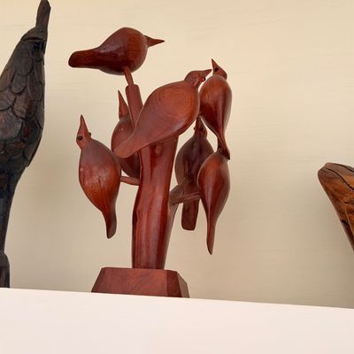 Sale Photo Thumbnail #33: Mid-century modern hand-carved wooden sculpture featuring multiple birds perched on a stylized tree branch, finished in a warm reddish-brown stain.