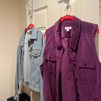 D&Co. purple corduroy vest paired with a light-wash denim jacket hanging on a door, both in good condition.