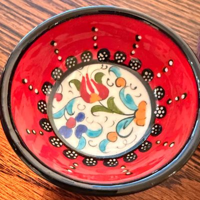 Sale Photo Thumbnail #102: Hand-painted Turkish ceramic pinch bowl featuring a red rim and colorful floral design at the center.