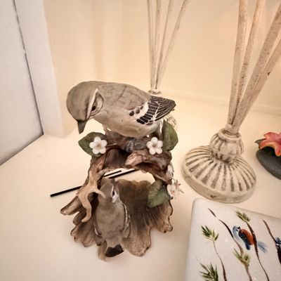 Sale Photo Thumbnail #23: Vintage porcelain bird figurine featuring two grey birds perched on a branch with white blossoms.