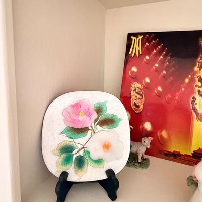 Sale Photo Thumbnail #10: Vintage Japanese cloisonné enamel plate featuring pink and white camellia blossoms, displayed on a black stand.