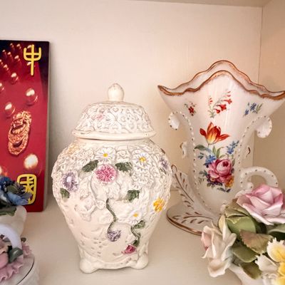 Sale Photo Thumbnail #11: Vintage ceramic ginger jar with raised floral details and a matching lid, displayed alongside a hand-painted floral vase with gold trim.