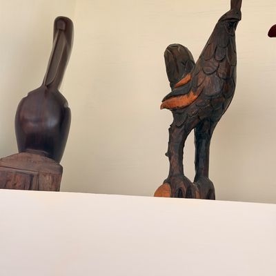 Sale Photo Thumbnail #34: Two hand-carved wooden bird sculptures, including a stylized pelican and a detailed rooster, displayed on a high shelf.