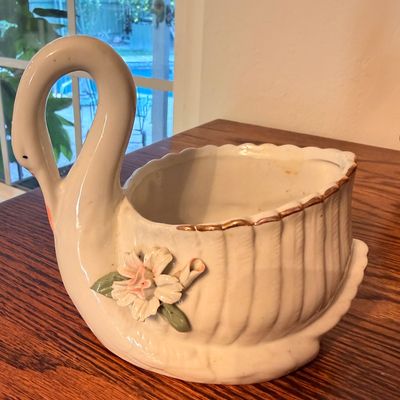 Sale Photo Thumbnail #83: Vintage ceramic swan planter featuring applied floral details and gold gilt rim trim.