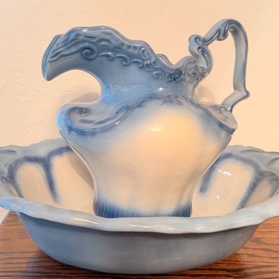 Sale Photo Thumbnail #64: Vintage ceramic pitcher and wash basin set featuring embossed scrollwork and a light blue ombre glazed finish.