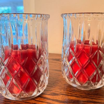 Sale Photo Thumbnail #79: Pair of vintage cut glass hurricane candle holders with diamond and vertical cut patterns, each containing a red candle.