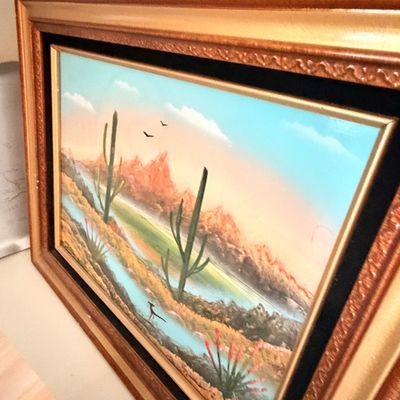 Sale Photo Thumbnail #18: Mid-century desert landscape oil painting featuring saguaro cacti, mountains, and a roadrunner, housed in an ornate tiered wooden frame with a black velvet liner.
