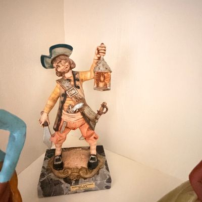 Sale Photo Thumbnail #17: Vintage Italian hand-painted pirate figurine, crafted from genuine Carrara marble and depicting a pirate holding a lantern and a dagger.
