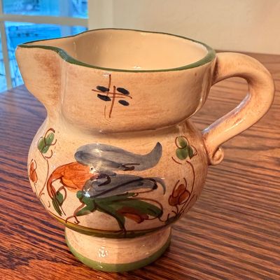 Sale Photo Thumbnail #82: Hand-painted Italian majolica pottery pitcher featuring a bird motif and green trim.