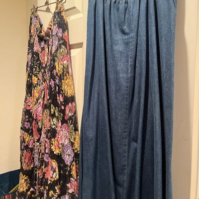 Two vintage long skirts hanging on a door hook, featuring a floral print tiered maxi skirt alongside an elastic-waist denim maxi skirt.