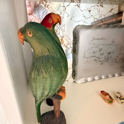 Sale Photo Thumbnail #19: Hand-carved and painted wooden parrot figurines perched on branches, displayed alongside a vintage Jamaica souvenir tray.