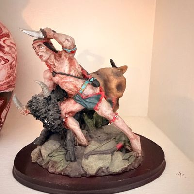 Sale Photo Thumbnail #26: Hand-painted resin figurine depicting a Native American warrior hunting a buffalo, mounted on a dark wooden base.
