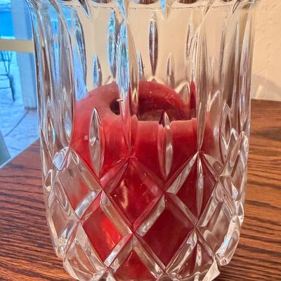 Sale Photo Thumbnail #78: Heavy cut crystal hurricane candle holder featuring crisscross diamond and vertical panel etching, housing a red pillar candle.