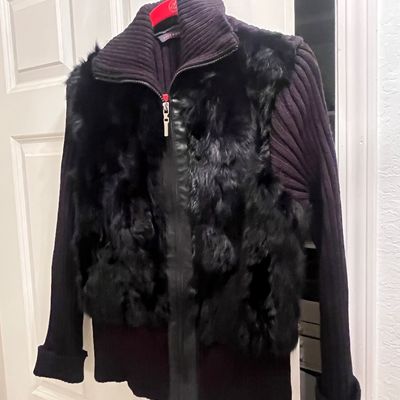 Black zip-up sweater jacket with ribbed knit sleeves, a high collar, and a plush faux-fur front bodice panel.