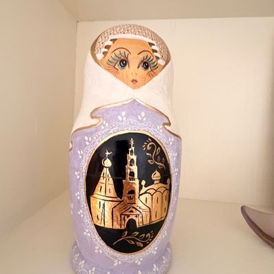 Sale Photo Thumbnail #9: Hand-painted Russian nesting doll featuring a lavender and white color scheme with a gold-leaf illustration of an Orthodox church.