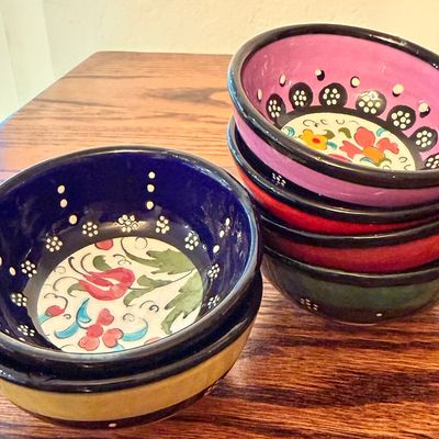 Sale Photo Thumbnail #98: Set of colorful hand-painted ceramic prep bowls with traditional floral motifs and dark rims.