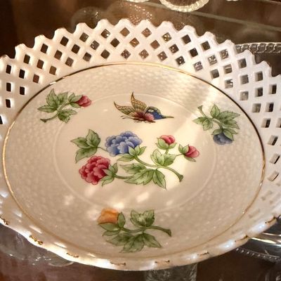 Sale Photo Thumbnail #110: Vintage reticulated porcelain bowl featuring a hand-painted floral and butterfly motif with gilt trim.