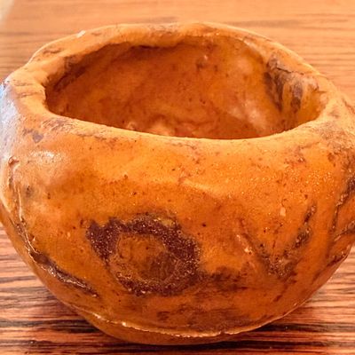 Sale Photo Thumbnail #62: Handcrafted terracotta or stoneware pinch pot with an earthy orange glaze and dark brown mottling.