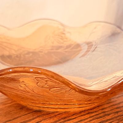 Sale Photo Thumbnail #65: Vintage amber glass shallow bowl with crimped, ruffled rim and molded floral pattern, likely mid-20th century Depression-style glass.