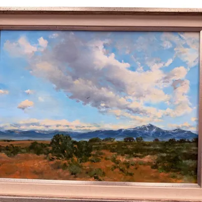 Sale Photo Thumbnail #32: Framed oil landscape painting depicting a desert valley with distant mountains under a dramatic, cloudy blue sky.
