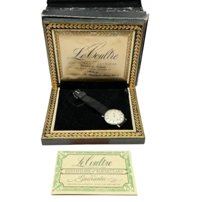 Sale Photo Thumbnail #65: Vintage LeCoultre ladies' wristwatch with a black strap, presented in its original ornate display box with a Certificate of Particulars and Guarantee card.