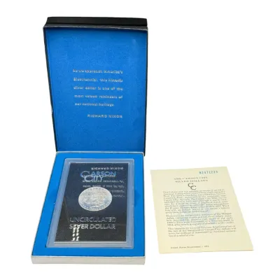 Sale Photo Thumbnail #61: GSA uncirculated Carson City Morgan silver dollar in its original blue presentation box with the accompanying certificate of authenticity.