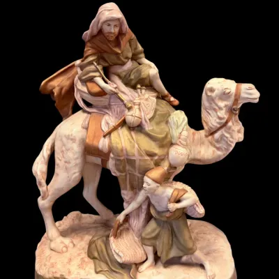 Sale Photo Thumbnail #20: Vintage Royal Dux porcelain figurine depicting a man riding a camel with an attendant on foot, featuring a matte finish in muted earth tones.
