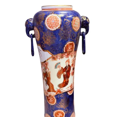 Sale Photo Thumbnail #12: Japanese Satsuma or Kutani style porcelain vase featuring a cobalt blue ground with gilt detailing, hand-painted panels depicting figures, and molded ring handles.