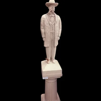Sale Photo Thumbnail #47: Vintage Jack Daniel's plaster statue depicting the founder in a frock coat and cowboy hat, standing atop a matching fluted pedestal column.
