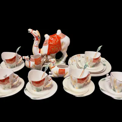 Sale Photo Thumbnail #30: Vintage Japanese porcelain camel-themed tea set, featuring a camel teapot, creamer, sugar bowl, and six matching cups, saucers, and spoons with red and gold accents.