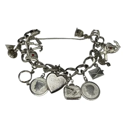 Sale Photo Thumbnail #64: Vintage sterling silver charm bracelet featuring a variety of charms including a heart, coins, a suitcase, an envelope, and a bell.