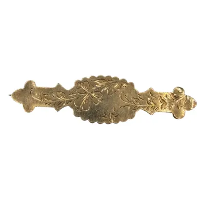 Sale Photo Thumbnail #63: Antique gold-filled bar brooch featuring hand-engraved floral and leaf motifs, circa late 19th to early 20th century.