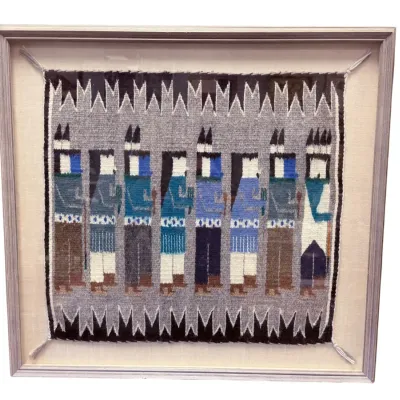 Sale Photo Thumbnail #24: Framed Navajo Yei pictorial weaving, featuring eight stylized figures in shades of blue, grey, brown, and white, mounted under glass in a simple wooden frame.