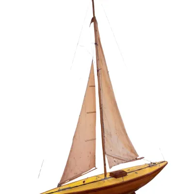 Sale Photo Thumbnail #43: Vintage wooden pond yacht model featuring a polished hull, planked deck, and fabric sails, showing some age-related wear.