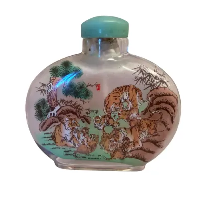 Sale Photo Thumbnail #49: Chinese inside-painted glass snuff bottle depicting tigers in a landscape, topped with a light green stopper.