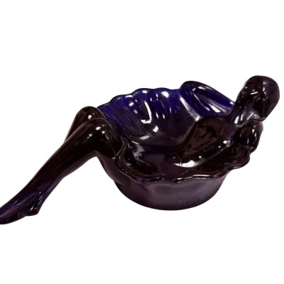 Sale Photo Thumbnail #50: Vintage cobalt blue glass pin-up girl ashtray, featuring a reclining female figure draped over the edge of a scalloped bowl.