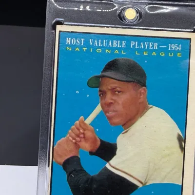 Sale Photo Thumbnail #60: Vintage 1955 Topps Willie Mays baseball card, commemorating his 1954 National League Most Valuable Player award, housed in a protective plastic case.