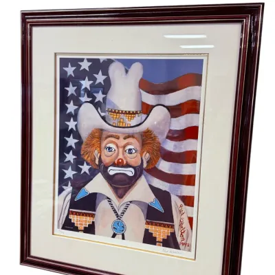 Sale Photo Thumbnail #34: Framed and matted Red Skelton clown print depicting a sad clown in a cowboy hat against an American flag background, signed and dated 1993.