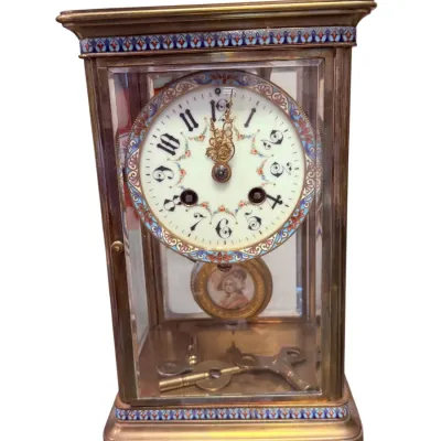 Sale Photo Thumbnail #8: Antique French brass carriage clock featuring champlevé enamel borders, a hand-painted porcelain dial, and a portrait pendulum, complete with winding keys.